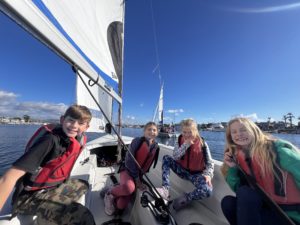 Two boys and two girls sailing on a RS Quest dinghy